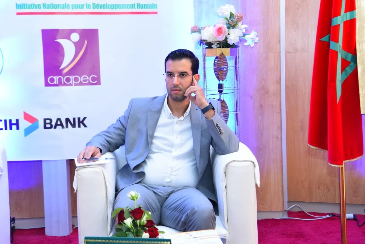 Abdelmajid Charrass en costume clair dans un fauteuil lors d’une table ronde.